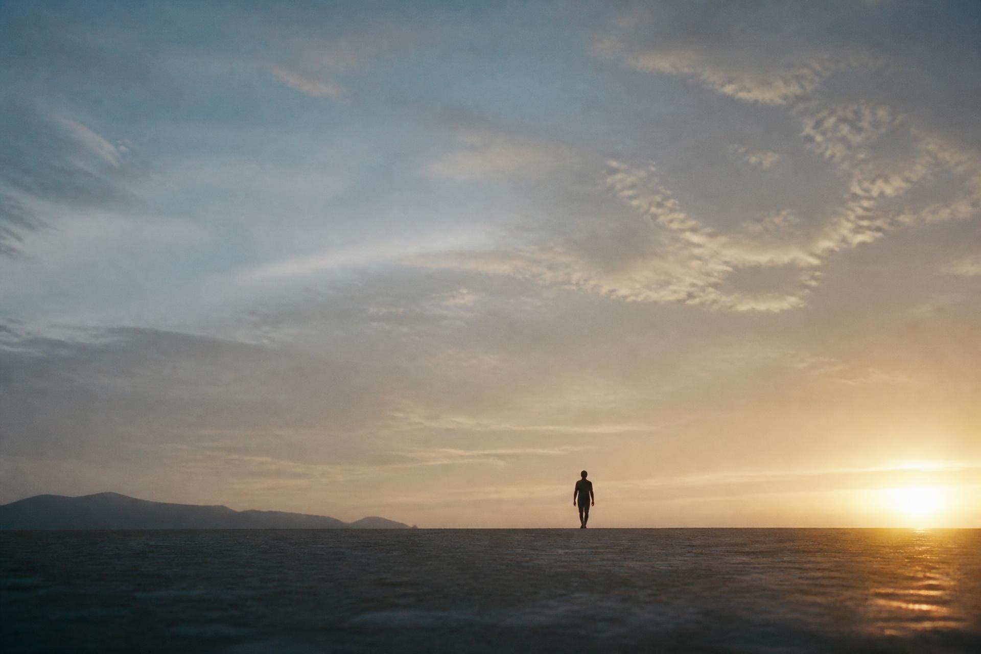 Climber silhouetted against a mountain sunrise